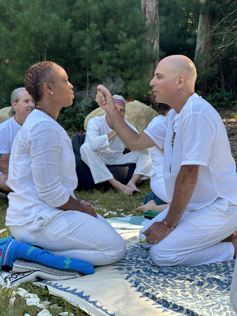 Ceremony blessing between facilitator and participant in a forest