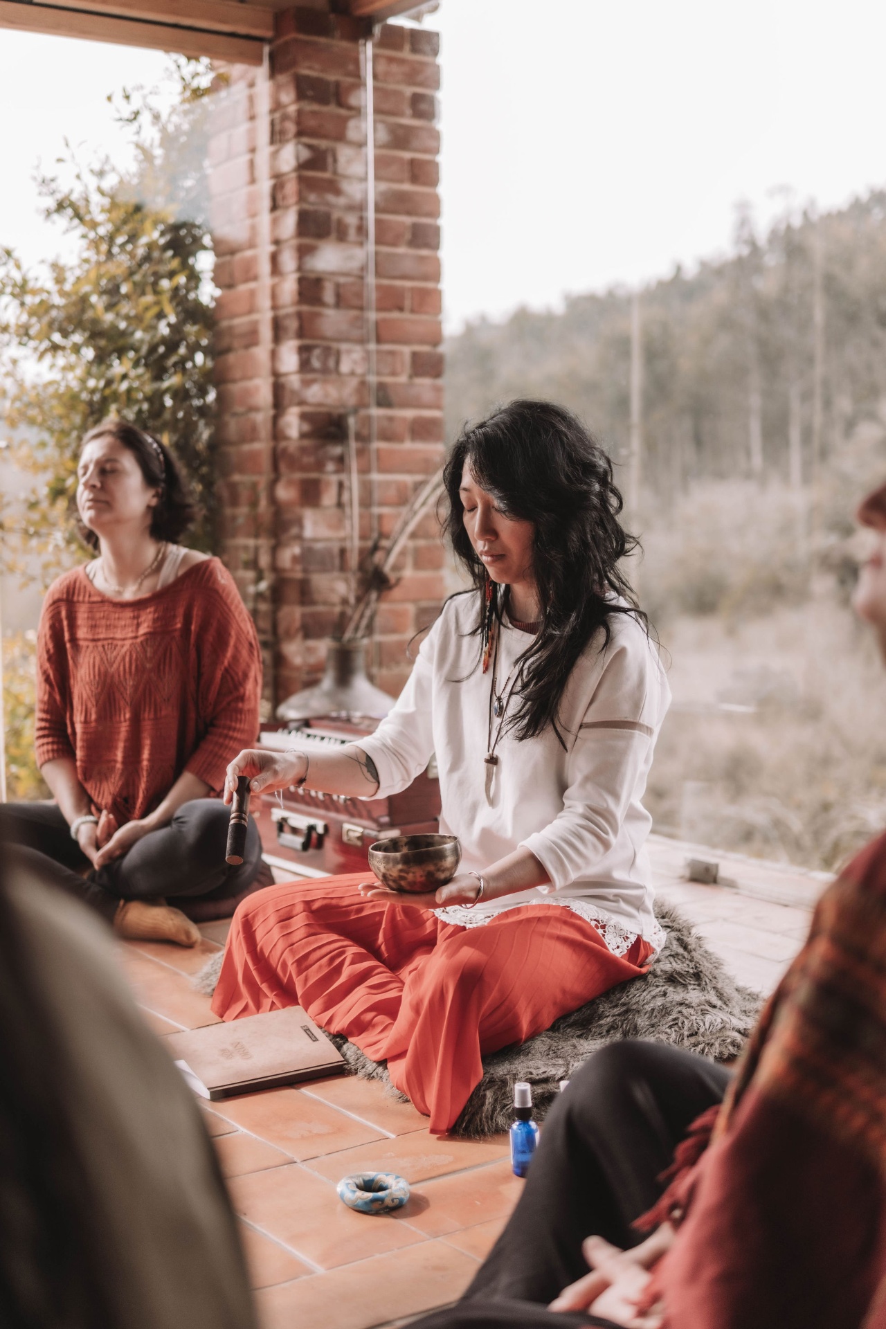 Sophie holding a singing bowl in a meditation circle