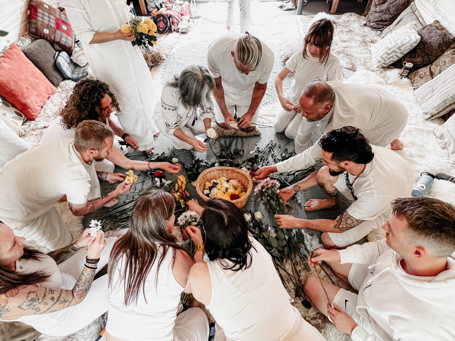 Group gathered in circle arranging flowers during ceremony